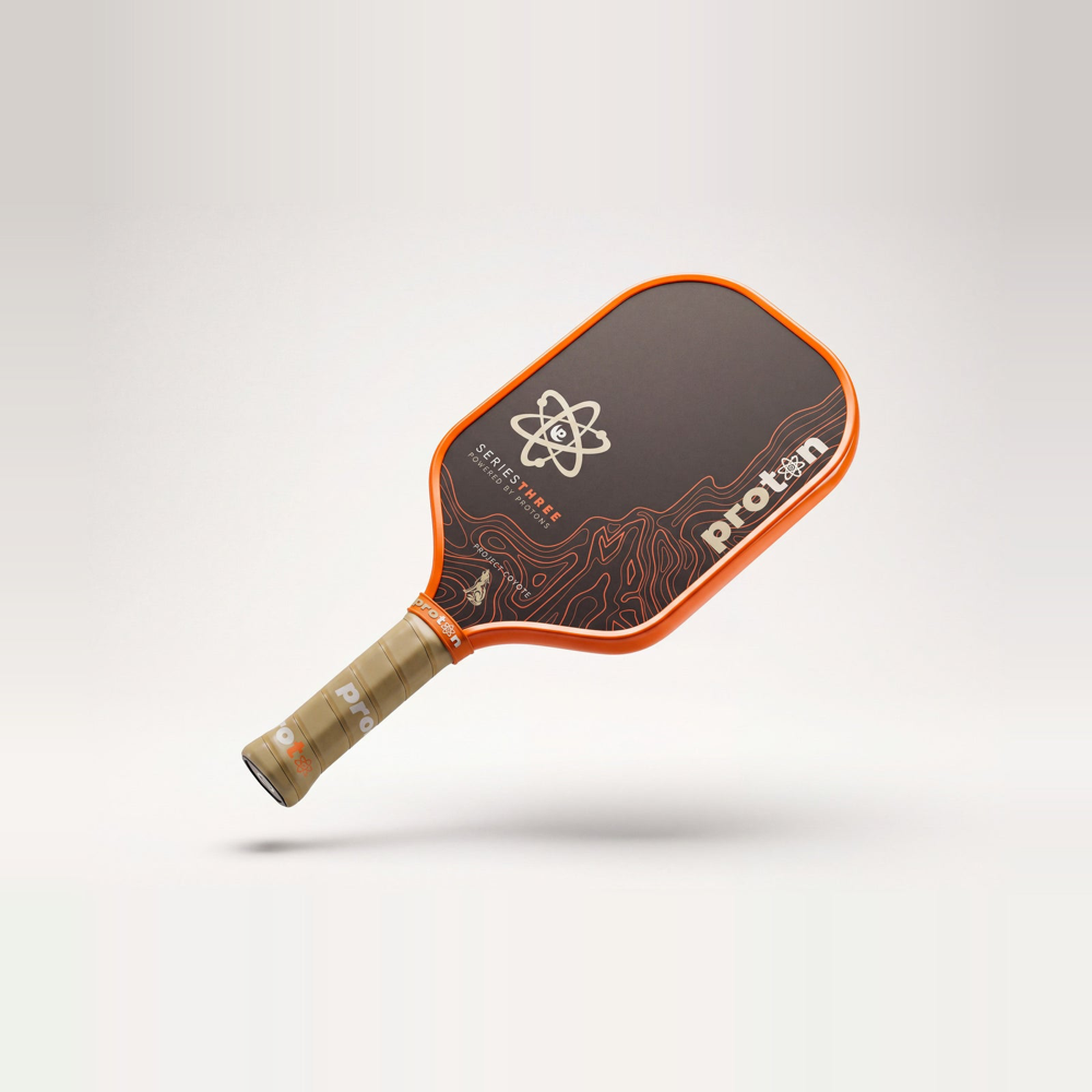 Proton Project Coyote Elongated 15mm pickleball paddle — front face, orange edge guard and tan grip